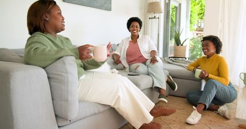 Friends chatting and enjoying coffee in cozy living room