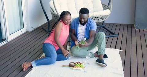 Couple Enjoys Wine and Snacks Together on Apartment Balcony