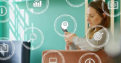 Woman Scrolling Smartphone in Modern Lounge with Virtual Tech Icons and Soft Light
