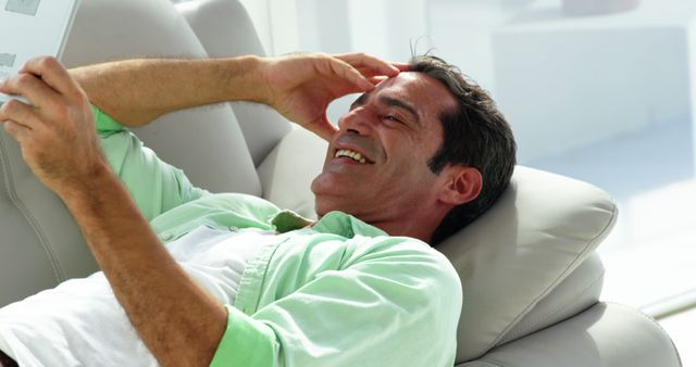 Man Reclining in Modern Interior Laughing While Reading - Download Free Stock Images Pikwizard.com