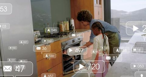 Parent teaching daughter baking in modern kitchen with ar notification overlays
