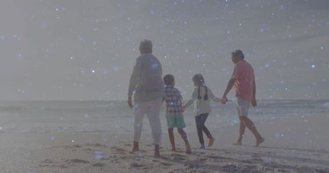 Multigenerational Family Enjoying Walk on Sandy Beach