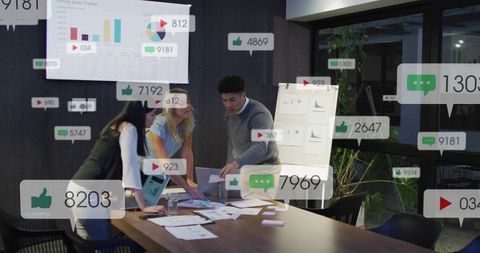 Team Collaborating on Marketing Analytics and Social Media Engagement Metrics in Office