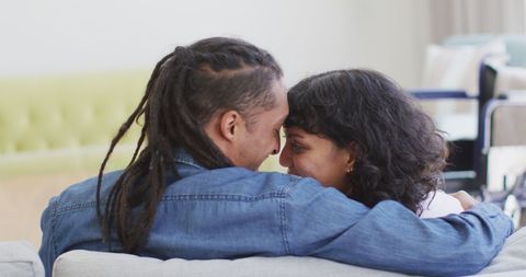 Happy Biracial Couple Embracing on Cozy Couch