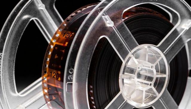 Clear plastic film reels with amber perforated 8mm celluloid strip, vintage cinema