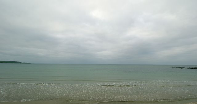 Tranquil beach scene on a cloudy day - Download Free Stock Photos Pikwizard.com