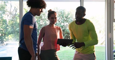 Friends Using Tablet to Enjoy Laughs in Sunny Home Environment