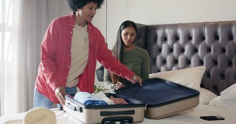 Diverse Couple Packing Suitcase for Adventure Trip