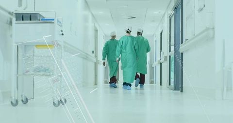 Medical team in surgical gowns walking down hospital corridor