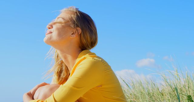 Woman Enjoying Sunlight on Breezy Beach Day - Download Free Stock Images Pikwizard.com