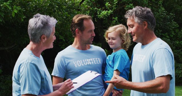 Caucasian senior couple and father and son wearing volunteer t shirts talking in field - Download Free Stock Photos Pikwizard.com