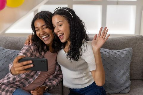 Joyful Sisters Taking Selfies Celebrating at Home
