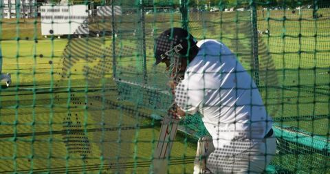 Batsman Practicing Cricket Swing Inside Net Cage