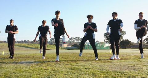 Team Training with High-Knee Drills at Sunrise on Sports Field