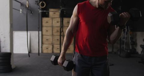 Athletic Man Lifting Dumbbells in Gym for Strength Workout