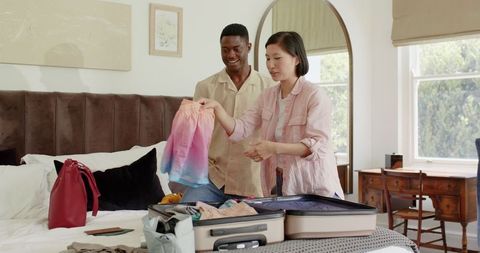 Couple Packing for Vacation in Cozy Modern Bedroom