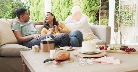 Happy Couple Relaxing Outdoors with Snacks and Celebration Cake