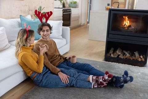 Couple Relaxing in Cozy Living Room by Fireplace During Holiday