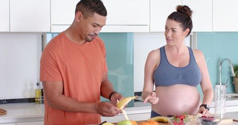 Diverse Couple Preparing Healthy Fruit Together in Modern Kitchen