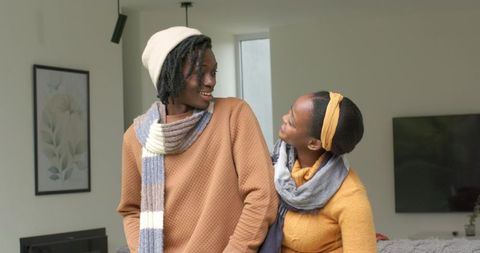 African American couple smiling and leaning toward each other in cozy modern living room