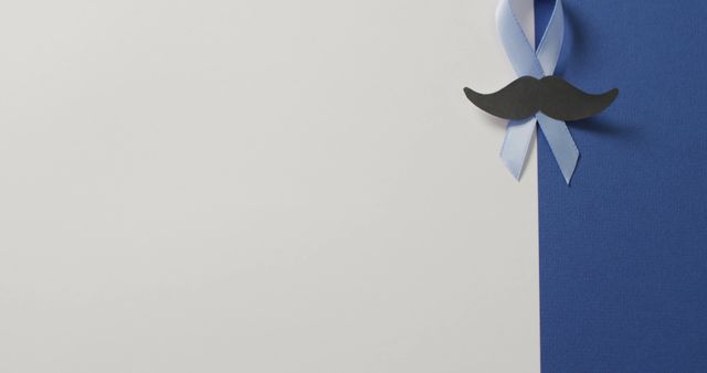 Blue ribbon and black mustache on blue and white background symbolizes men's health awareness. Ideal for health campaign materials, support group banners, health articles, and prostate cancer awareness promotions.
