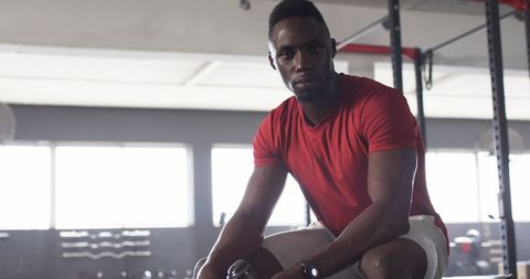Athletic Man Resting in Gym Post-Workout Holding Water Bottle