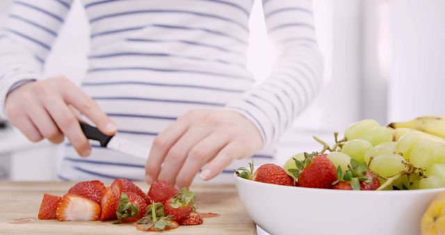 Person Wearing Striped Shirt Cutting Strawberries in Modern Kitchen - Download Free Stock Images Pikwizard.com