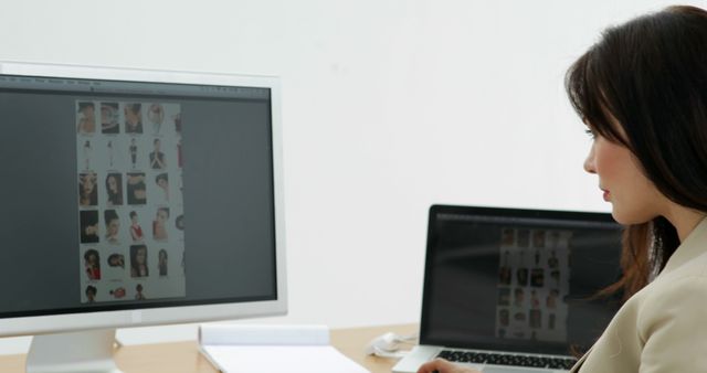 Photo editor choosing photos on computer screen in creative office