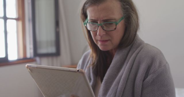 Senior Woman Reading Tablet in Comfortable Indoor Setting - Download Free Stock Images Pikwizard.com