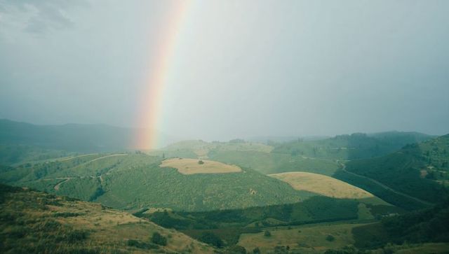 Rainbow arching over serene green valley