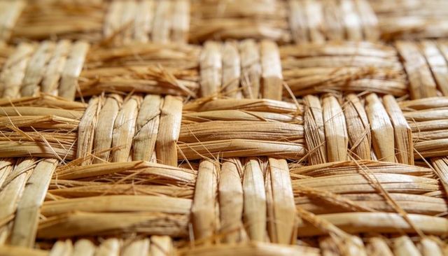 Displaying woven natural fiber mat texture with frayed ends and rustic straw weave