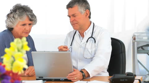 Doctor Explaining Patient's Health Report on Laptop in Office
