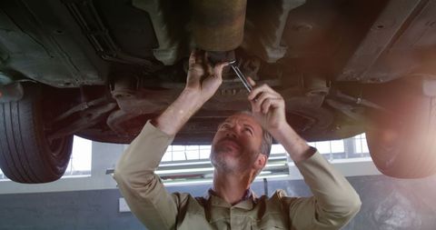 Mechanic Repairing Car Exhaust in Workshop - Download Free Stock Images Pikwizard.com