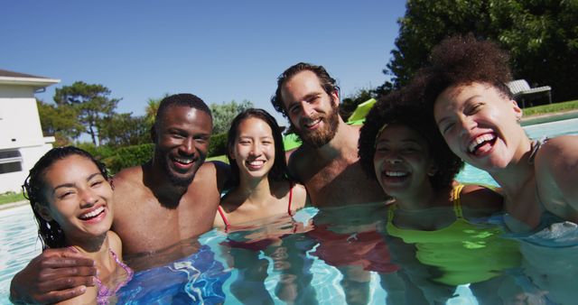 Diverse group of friends having fun taking a selfie in swimming pool. hanging out and relaxing outdoors in summer.