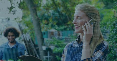 Smiling woman taking calls outdoors in fresh garden environment
