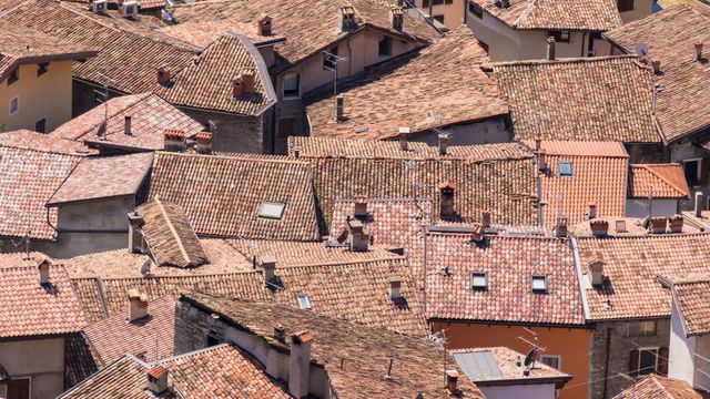 This image features a scenic aerial view of rooftops in a traditional European town in daylight. It highlights the old buildings with distinctive tiled roofs, capturing the charm and history of European architecture. Ideal for use in travel articles, cultural studies, historical features, and tourism websites to showcase European urban environments and traditional town aesthetics.