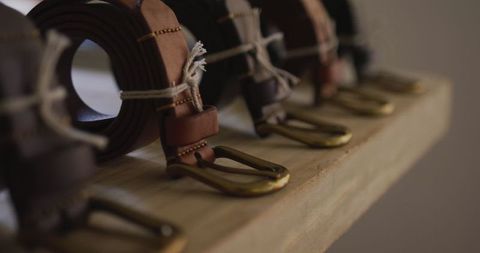 Handcrafted leather belts in artisan workshop with brass buckles