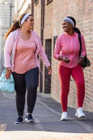 Walking and smiling: diverse friends walking together in urban activewear and headbands