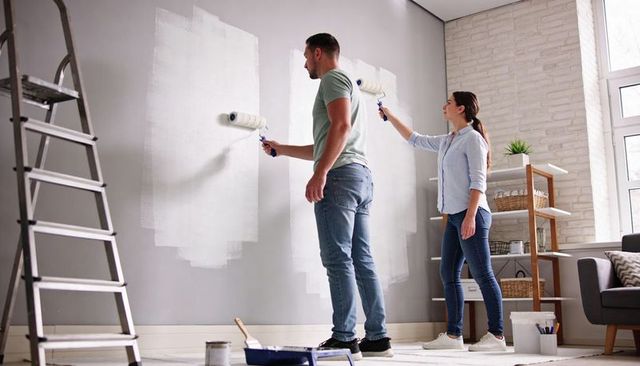 Couple Painting Living Room Wall Together Rolling White Paint DIY Home Renovation Interior
