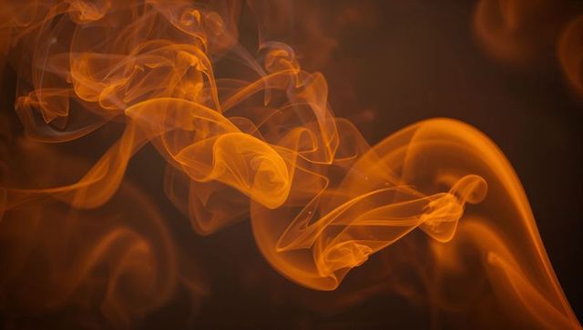 Vibrant Orange Smoke Against Dark Background