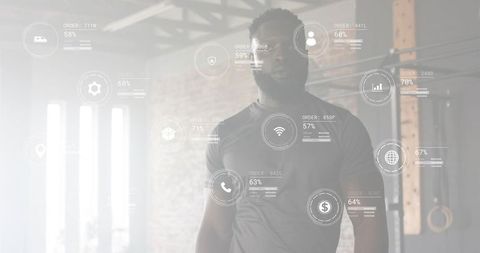 Standing male athlete in industrial gym with futuristic hud fitness data overlay