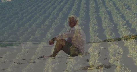 Senior man meditating on sandy beach with nature overlay