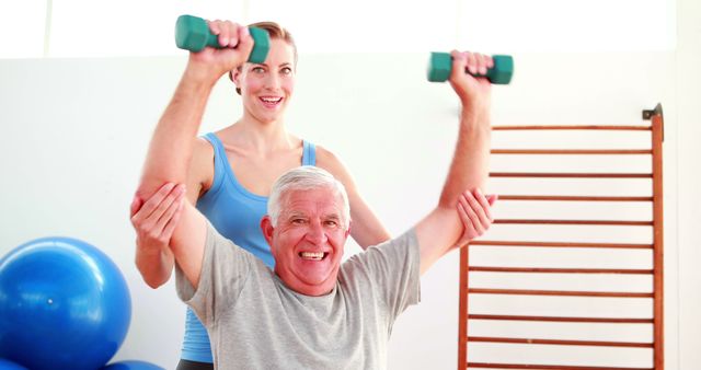 Smiling Senior Man Lifting Weights with Woman Personal Trainer in Gym - Download Free Stock Images Pikwizard.com