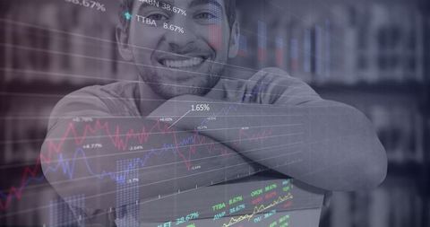 Smiling businessman with stock charts hologram overlay