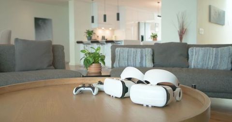 Dual white vr headsets resting on wooden coffee table in modern living room