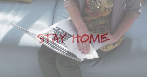 Woman Disinfecting Laptop with Stay Home Message