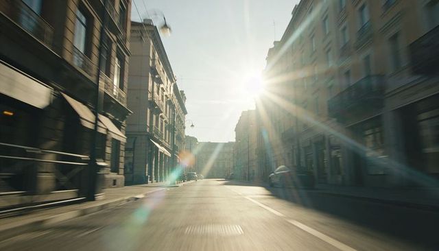 Sunlight streaming down empty urban street with lensflare, motion blur and deep perspective