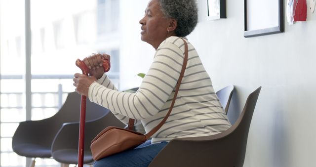 Elderly Woman Sitting in Waiting Room with Cane - Download Free Stock Images Pikwizard.com