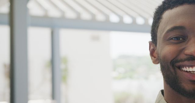 Image depicts a close-up of a smiling man outdoors with only a portion of his face visible. Ideal for use in advertisements, positive branding campaigns, blog posts about happiness and well-being, or any content needing a cheerful and friendly visual element.