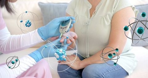 Caregiver checking blood glucose with glucometer during home care wellness visit